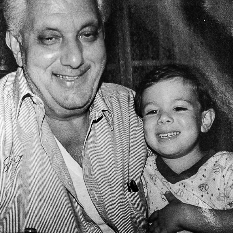 Grandfather and grandson share a joyful laugh in a vintage photograph.