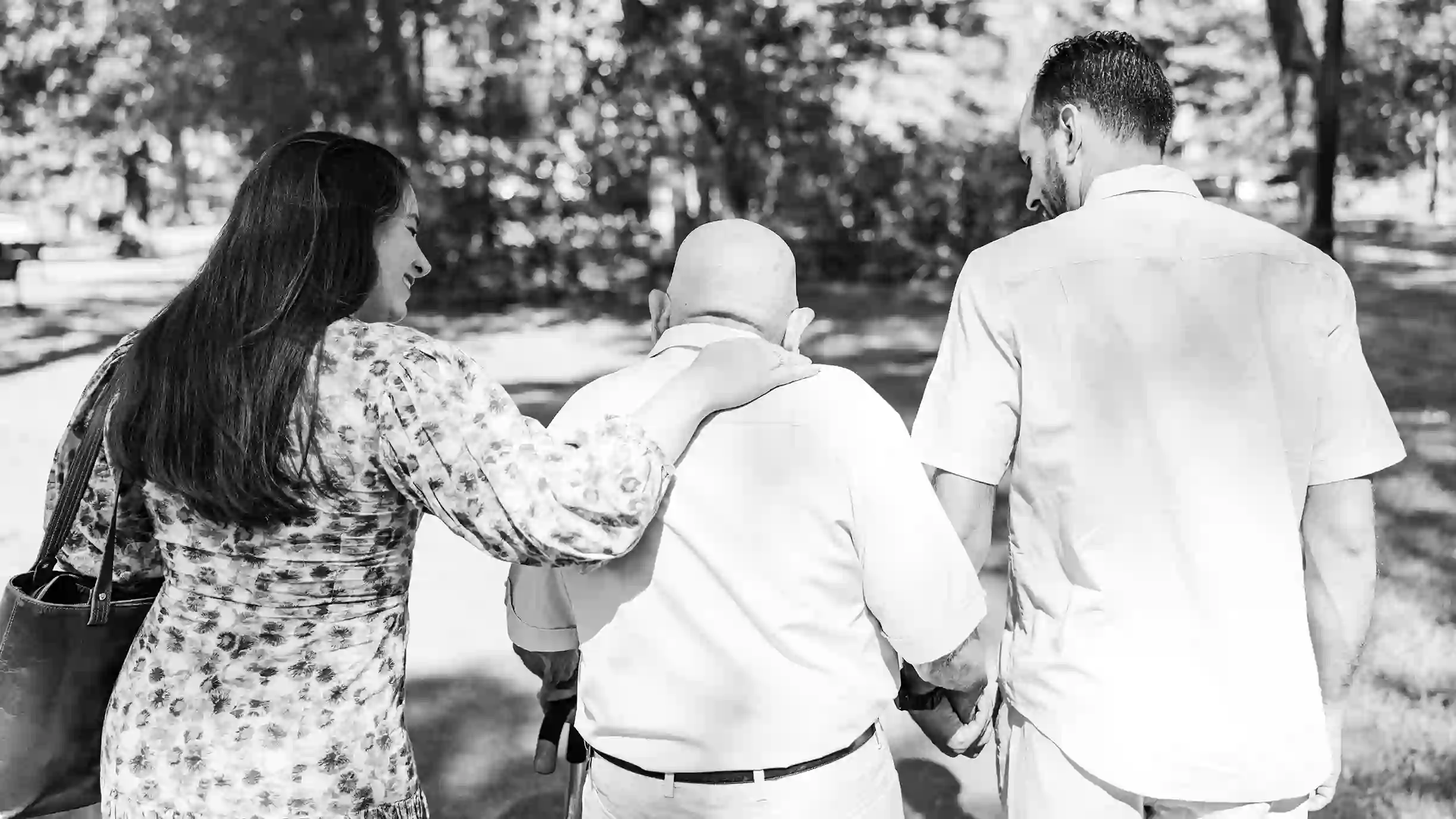 A family photograph of the grandchildren walking with their grandfather at a scenic park.