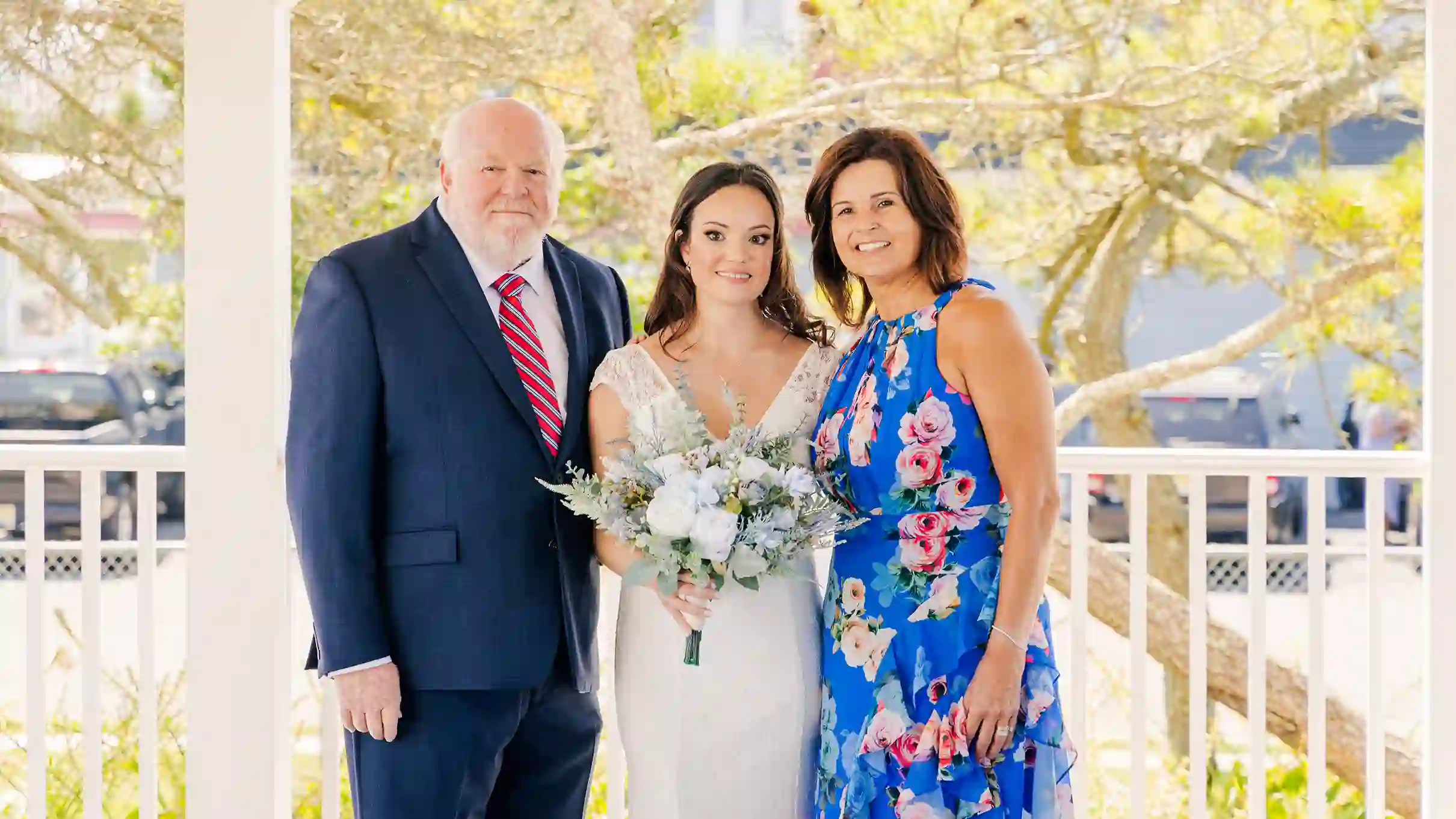 A bride smiling and posing with family after her wedding ceremony on a beautiful sunny day in Barnegat Light, NJ.