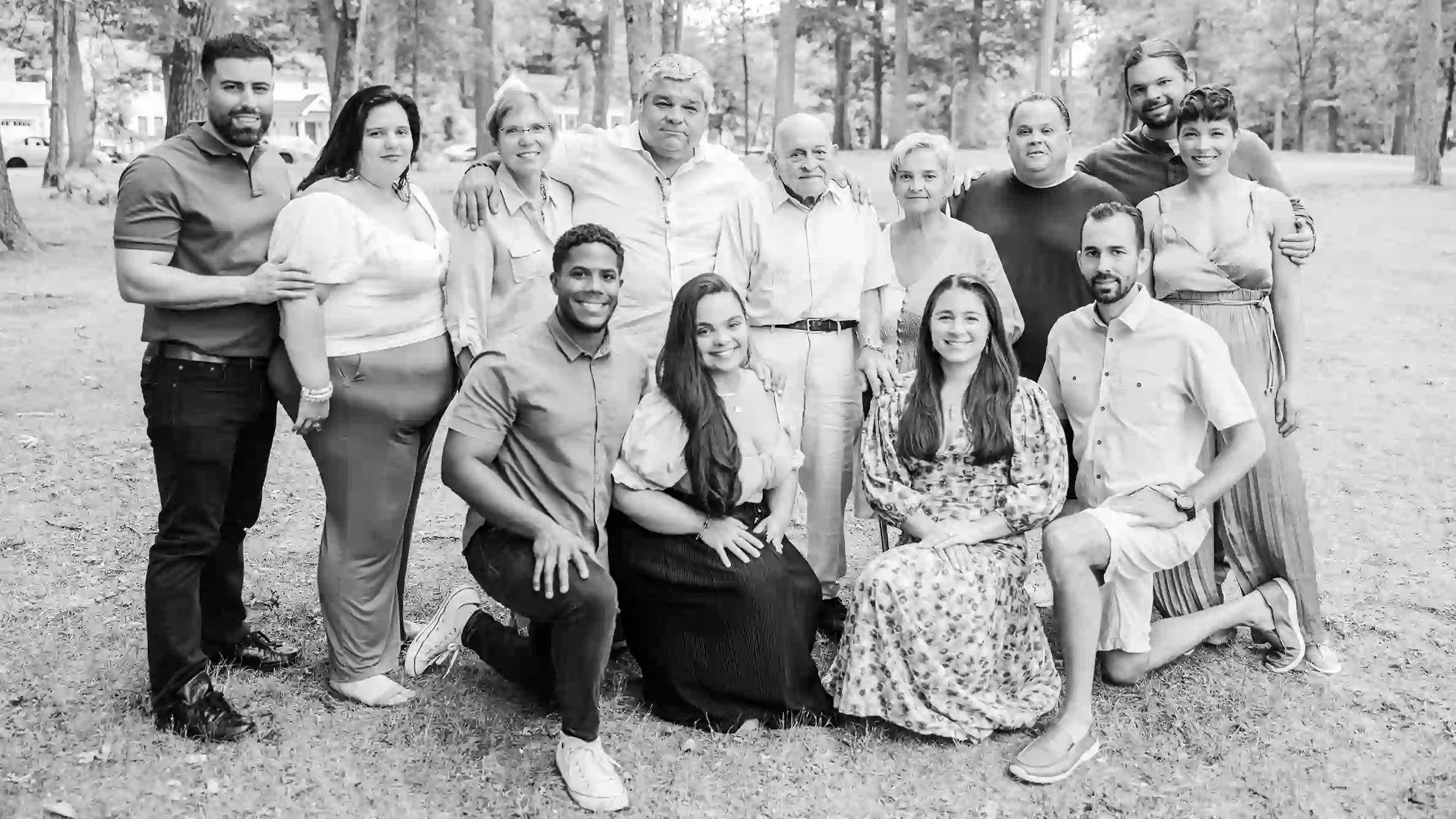 A historic family portrait taken at a park with beautiful scenery and trees.