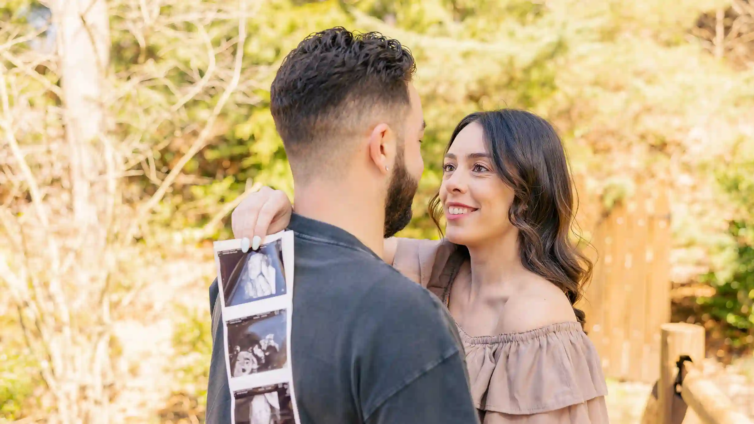 Excited couple, soon-to-be parents, glowing mom and dad hold their baby's sonogram.