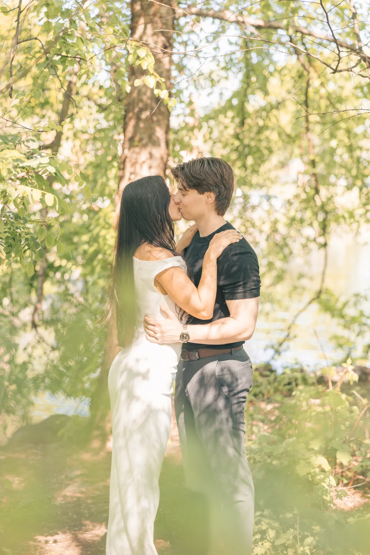 romantic-couple-kissing-green-trees-bokeh