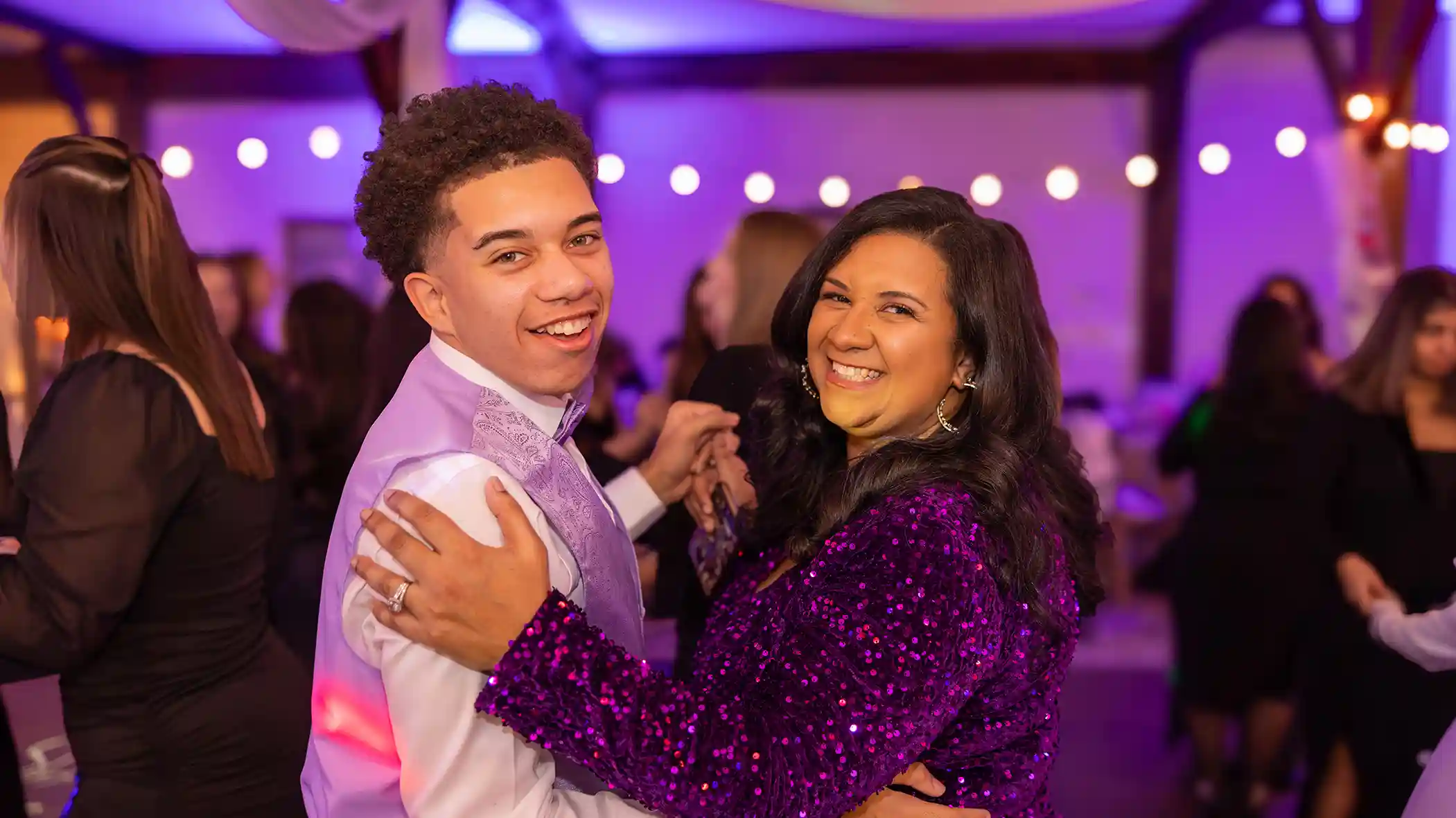 The mother of the birthday girl looking at the camera and dancing with her nephew.