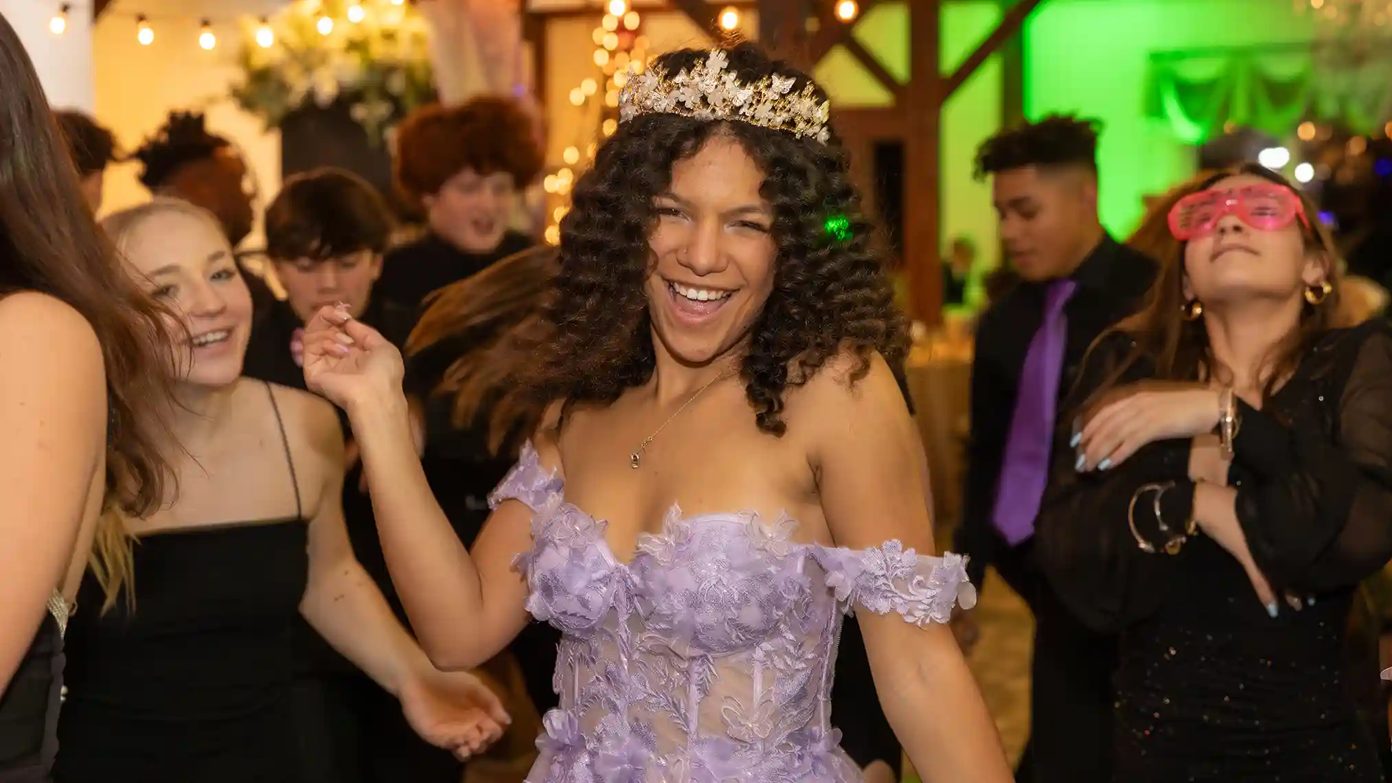 The birthday girl on the dance floor smiling, dancing and looking straight to camera.