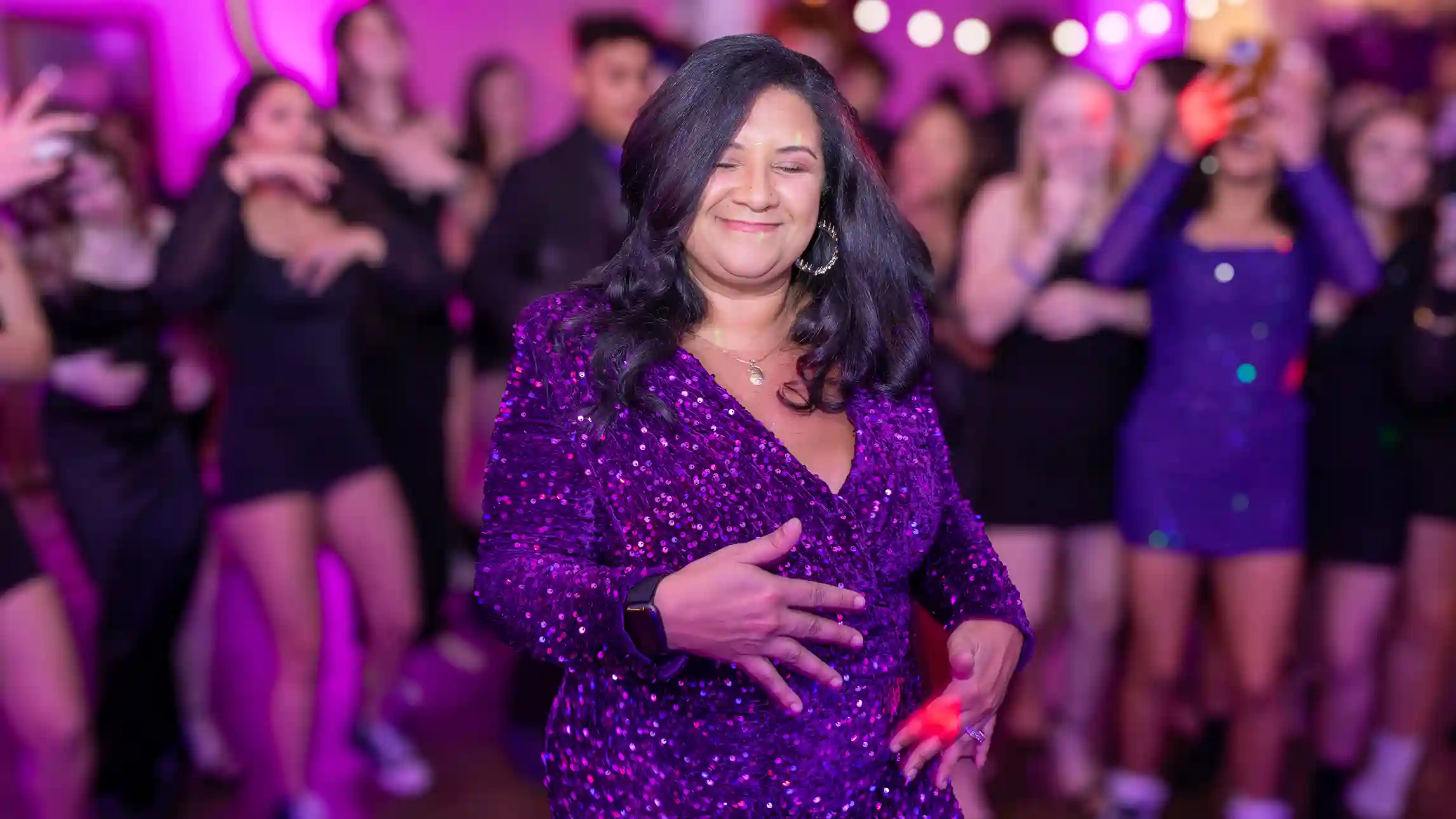 The mother of the birthday girl smiling on the dance floor and enjoying her moment.