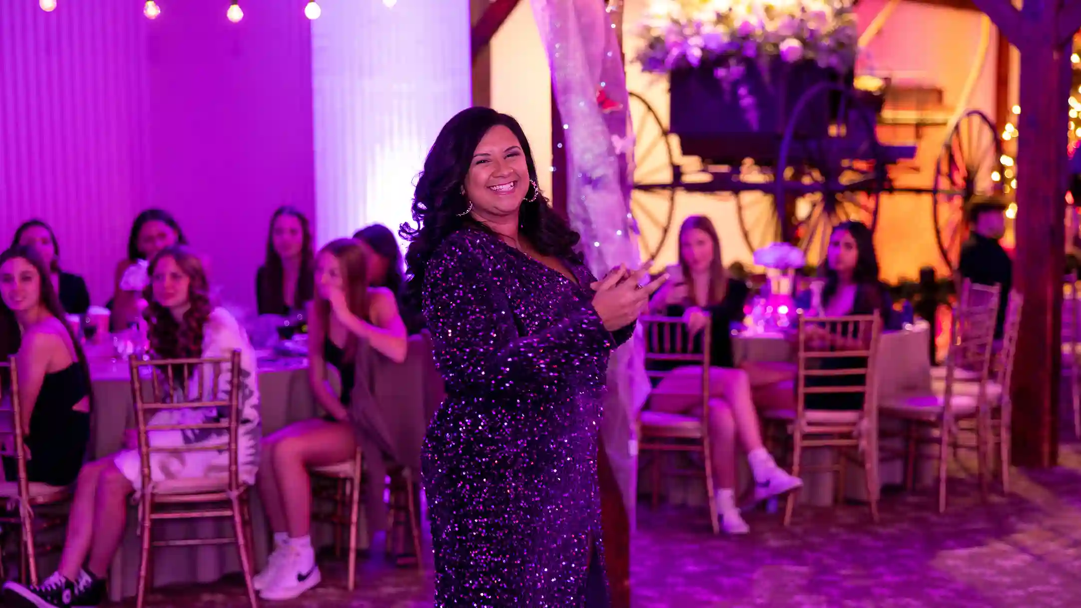 The mother of the birthday girl smiling on the dance floor looking at the camera.