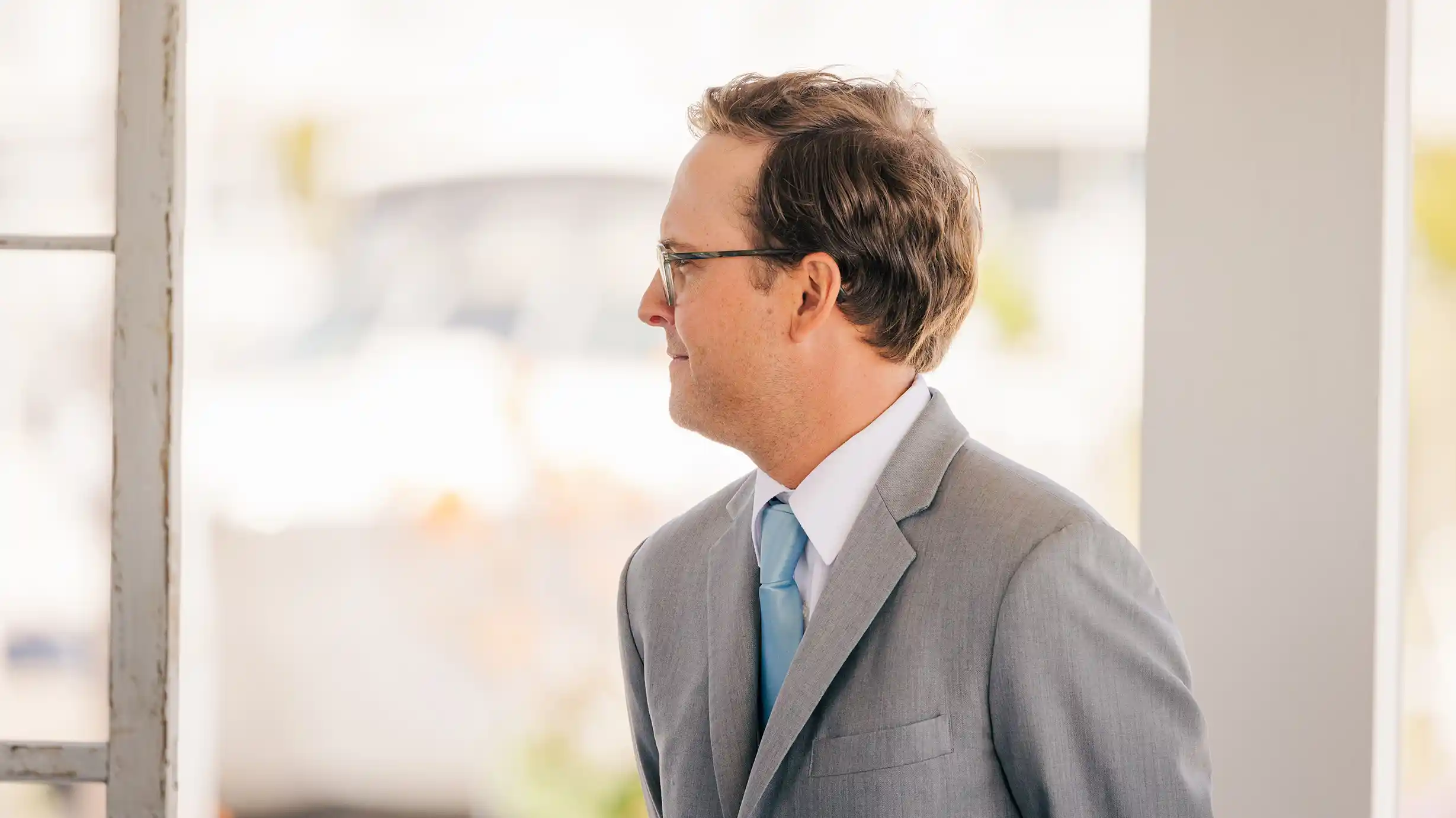 Best man, filled with joy, smiles at the happy couple during their wedding ceremony.