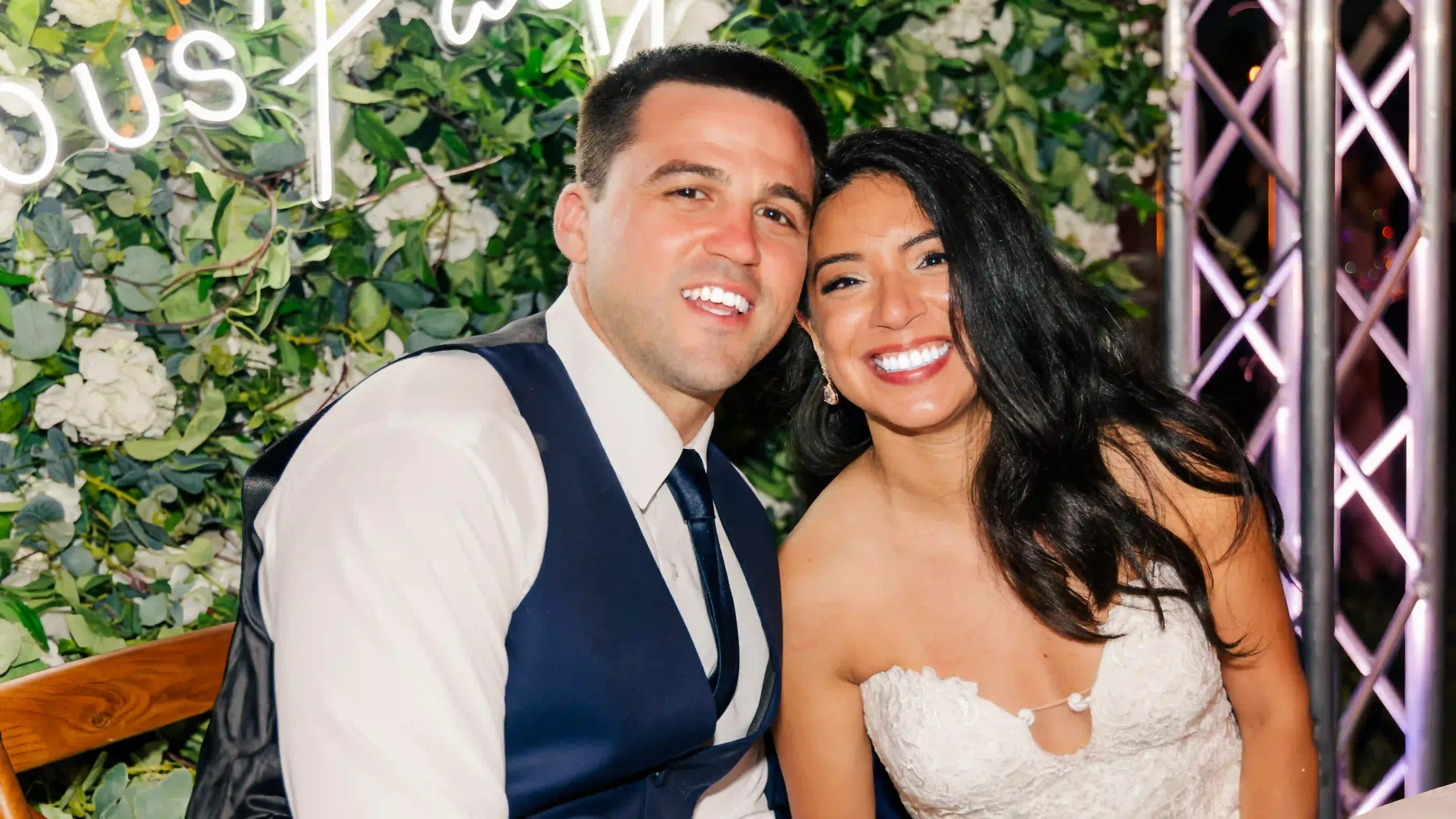 Joyful newlyweds, sharing a loving smile, celebrate their marriage surrounded by picturesque greenery.